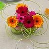 Tuintafel versieren met bloemen in glazen potjes is eenvoudig maar mooi met gekleurd steekschuim en pitriet